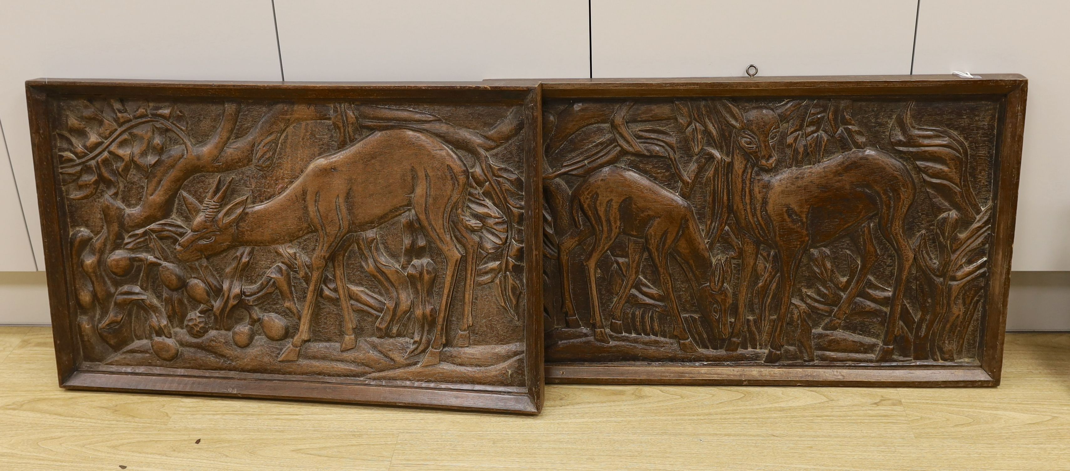 A pair of 1930's carved oak panels of deer grazing, 84 cms wide x 52 cms high.